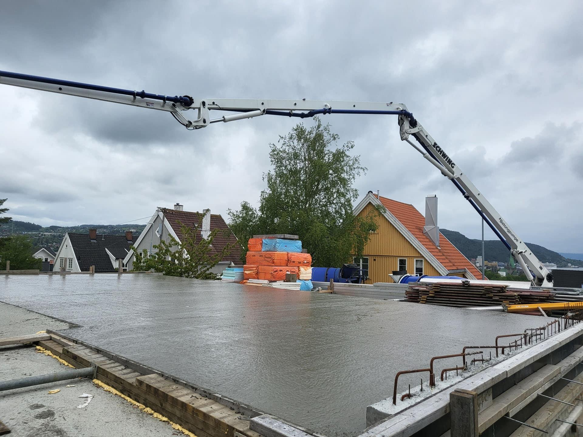 Betong pumpes ut over armering på et nytt tak over parkeringskjeller