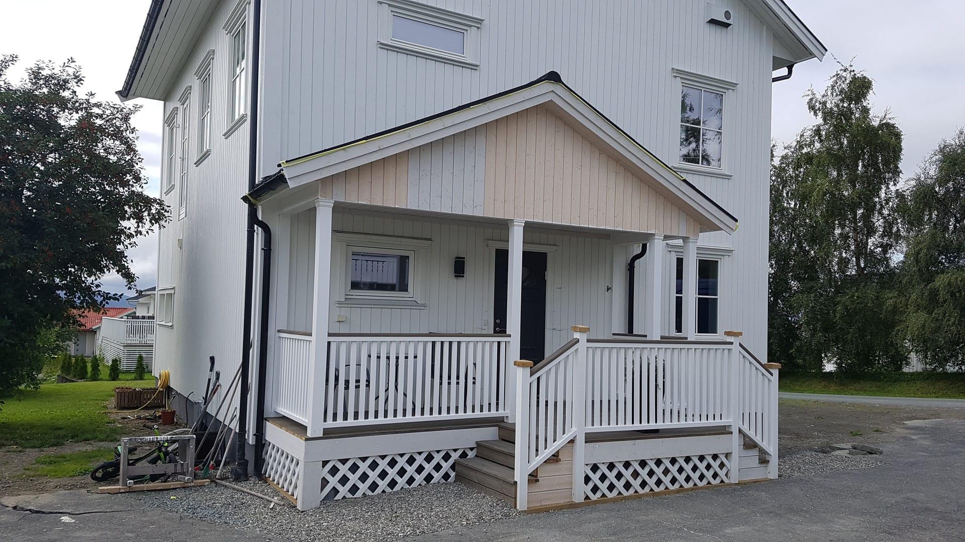 Hvitt hus med ny veranda og trapp med rekkverk